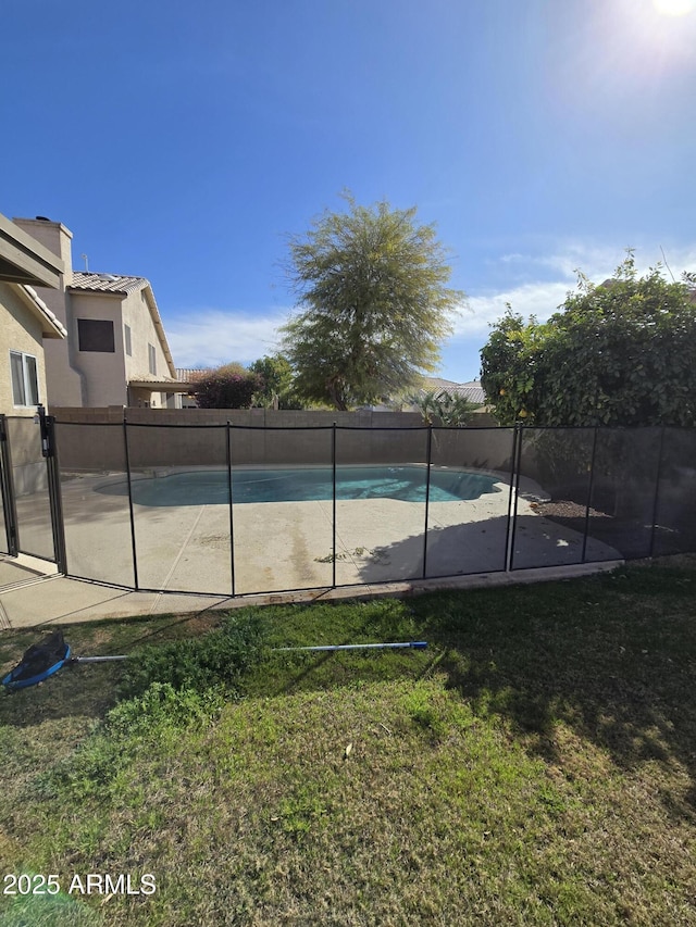 view of swimming pool with a yard