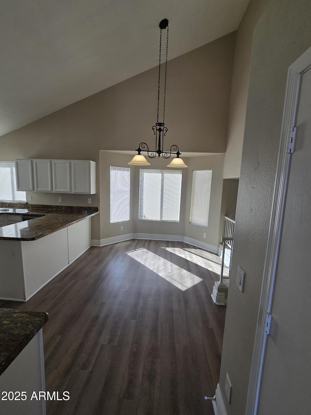 kitchen with white cabinetry, decorative light fixtures, a chandelier, high vaulted ceiling, and dark hardwood / wood-style floors