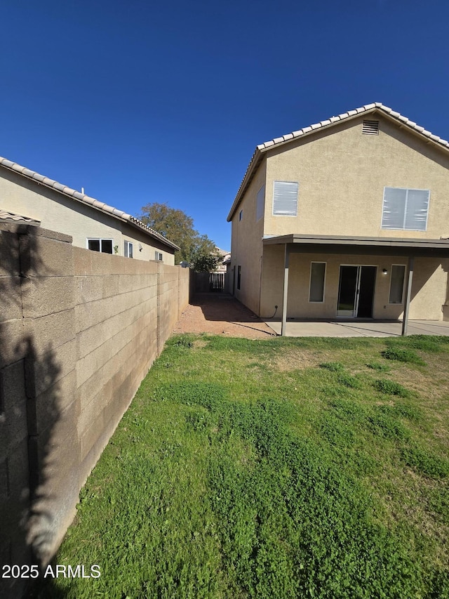 back of property featuring a patio and a yard