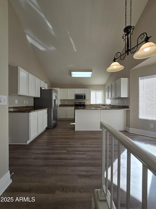 kitchen featuring appliances with stainless steel finishes, dark wood-type flooring, white cabinets, and decorative light fixtures