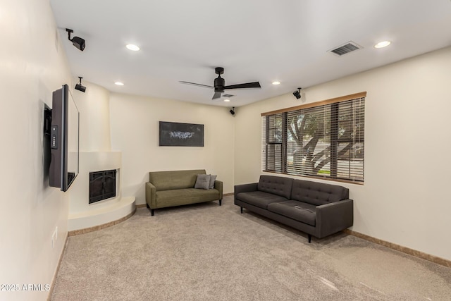 carpeted living room featuring baseboards, visible vents, a ceiling fan, a fireplace, and recessed lighting