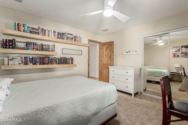 bedroom with light carpet, visible vents, a ceiling fan, and a closet