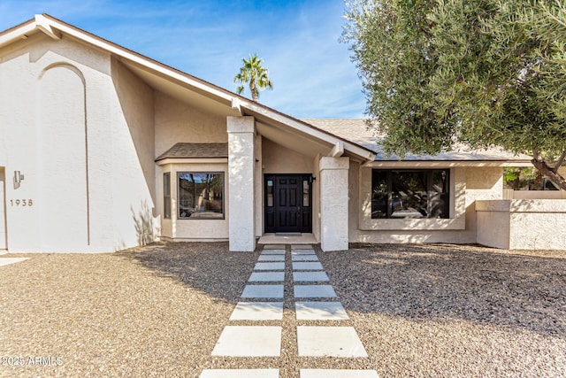 view of exterior entry with stucco siding