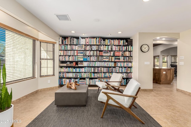 living area featuring arched walkways, visible vents, recessed lighting, and light tile patterned flooring