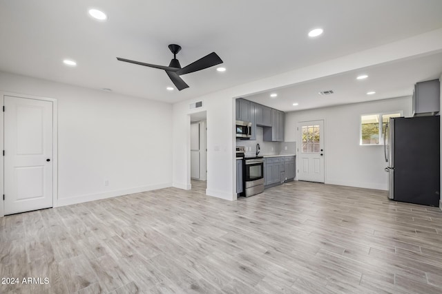 unfurnished living room with ceiling fan and light hardwood / wood-style floors