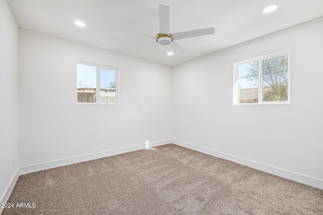 carpeted spare room featuring ceiling fan