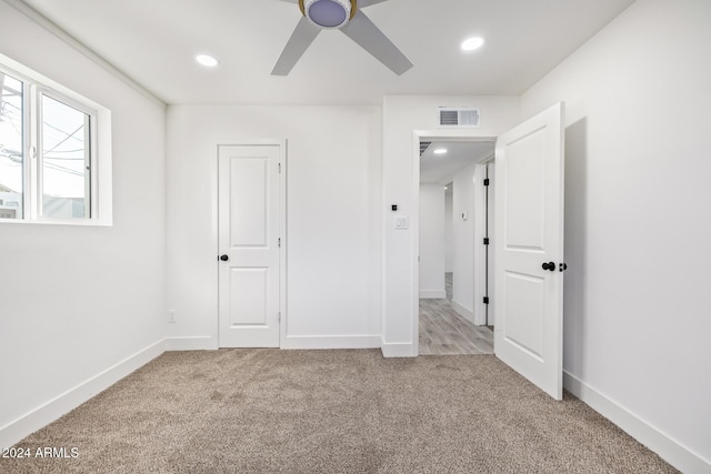 unfurnished bedroom featuring ceiling fan, light carpet, and a closet