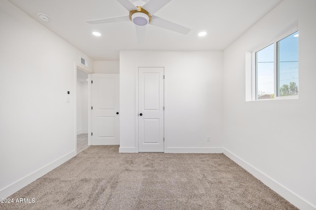 unfurnished room with ceiling fan and light colored carpet