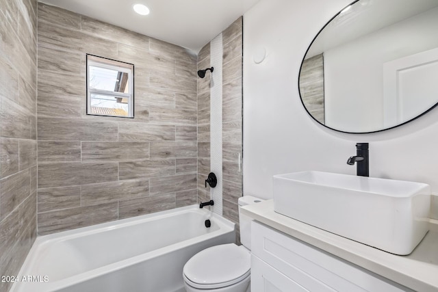 full bathroom with vanity, tiled shower / bath combo, and toilet