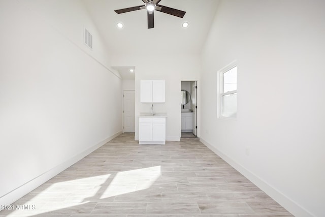 interior space featuring light hardwood / wood-style floors, high vaulted ceiling, and sink