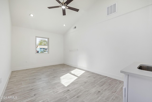 unfurnished room featuring ceiling fan, high vaulted ceiling, and light wood-type flooring