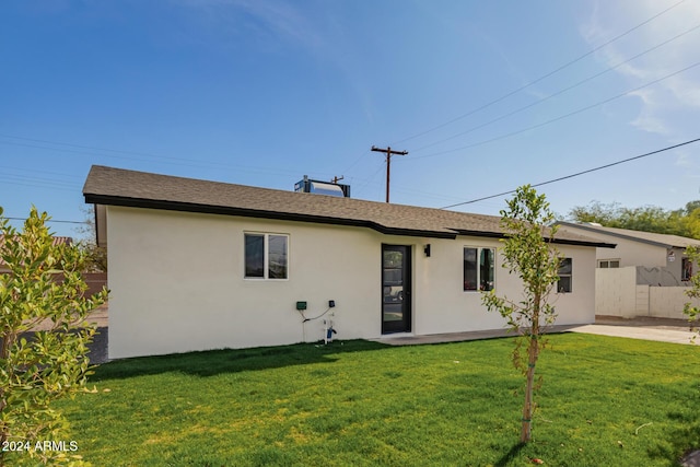 rear view of house featuring a lawn