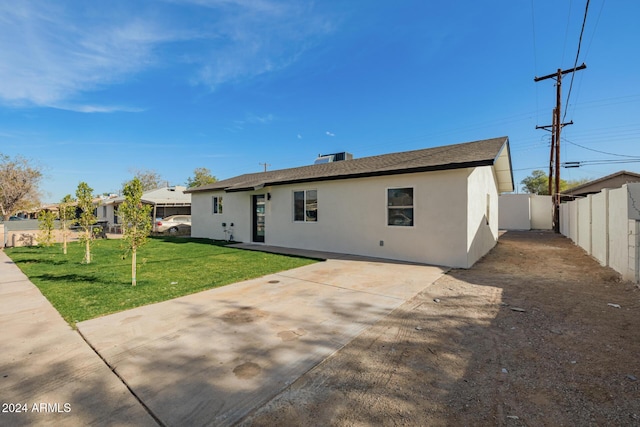 rear view of property with a patio area and a lawn