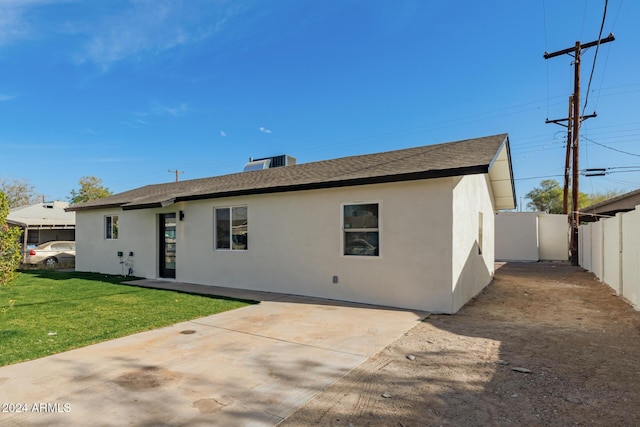 rear view of property featuring a lawn and a patio area