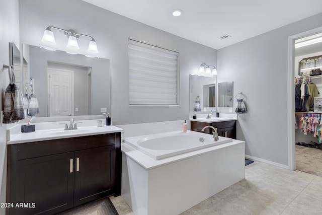 bathroom featuring tile patterned floors, vanity, and a tub to relax in