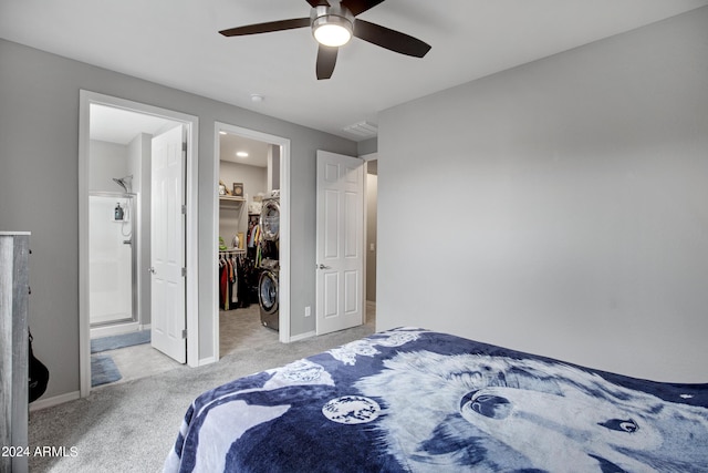 carpeted bedroom featuring a walk in closet, a closet, ensuite bath, and ceiling fan