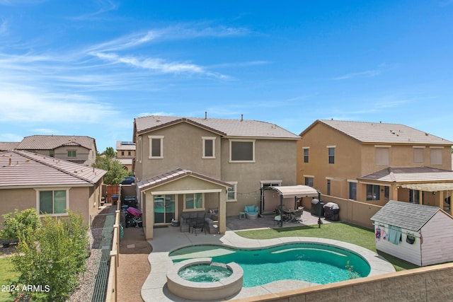 back of property with a fenced in pool and a patio