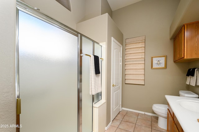 bathroom with tile patterned flooring, vanity, a shower with shower door, and toilet