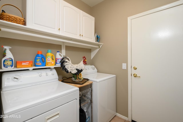 clothes washing area featuring cabinets and washing machine and clothes dryer