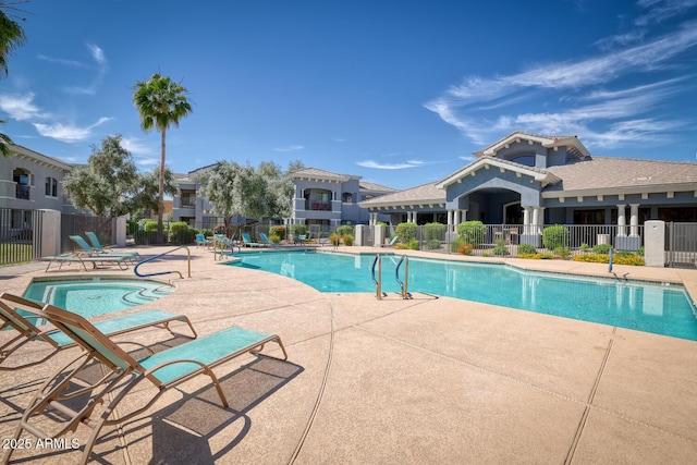 pool with a patio area and fence