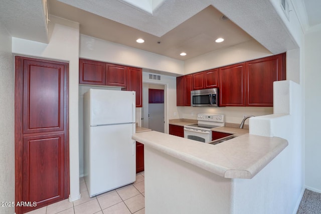 kitchen with light countertops, white appliances, visible vents, and dark brown cabinets