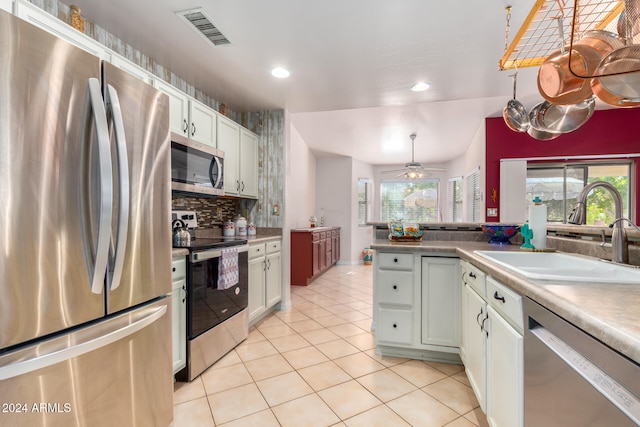 kitchen with white cabinetry, stainless steel appliances, backsplash, pendant lighting, and sink