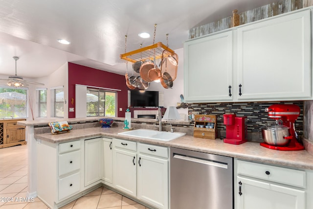 kitchen with dishwasher, kitchen peninsula, sink, light tile patterned flooring, and white cabinetry