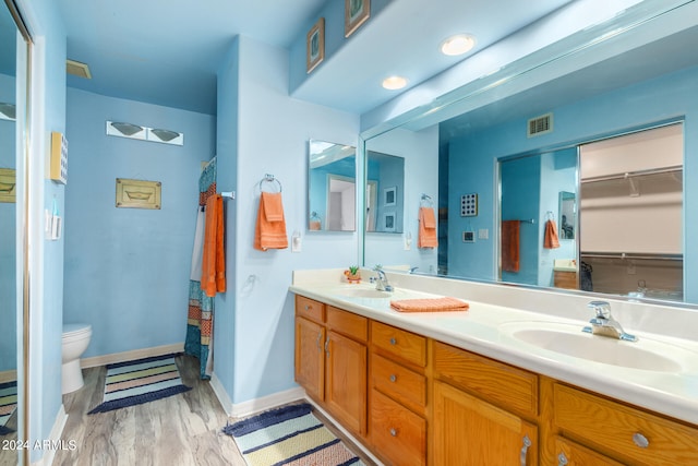 bathroom with toilet, hardwood / wood-style floors, vanity, and curtained shower