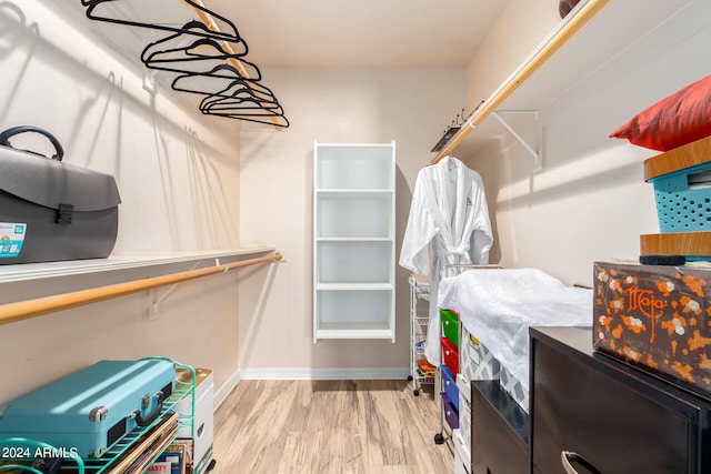 walk in closet with light hardwood / wood-style floors