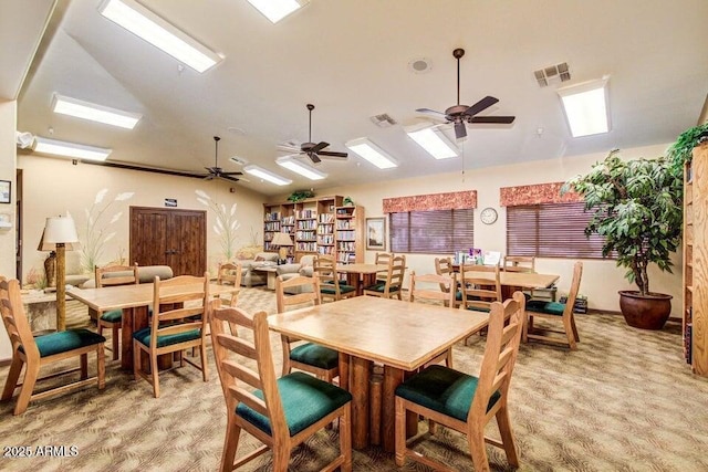 carpeted dining area with vaulted ceiling