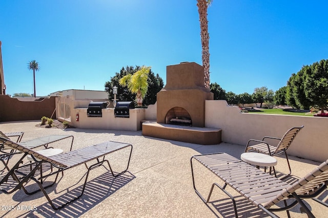 view of patio / terrace featuring an outdoor fireplace and exterior kitchen