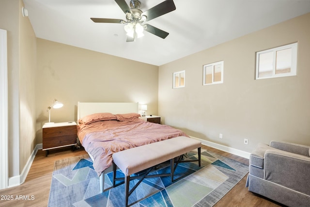 bedroom with ceiling fan, baseboards, and wood finished floors