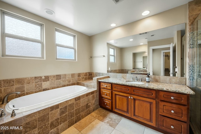 bathroom featuring tile patterned floors, visible vents, a garden tub, recessed lighting, and vanity