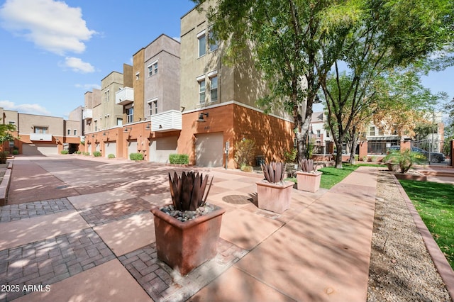 view of community featuring a garage, a residential view, and driveway