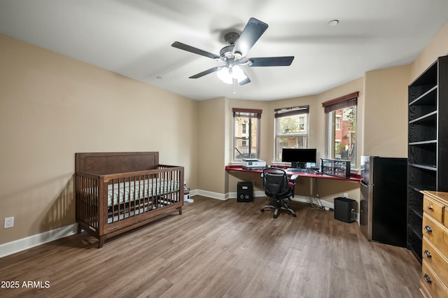 home office with a ceiling fan, wood finished floors, and baseboards