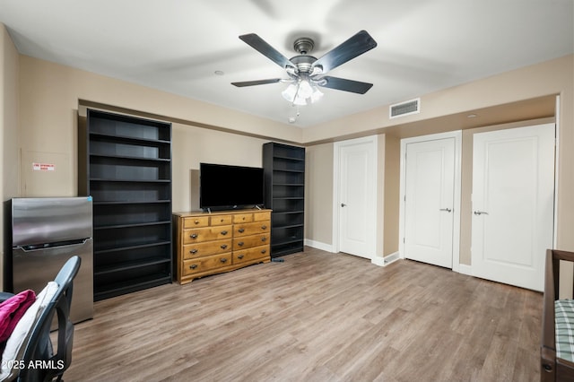 interior space featuring visible vents, baseboards, wood finished floors, and freestanding refrigerator