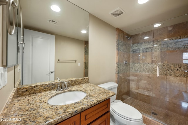 full bathroom featuring vanity, toilet, visible vents, and a stall shower