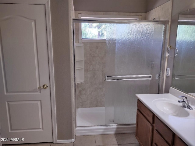 bathroom featuring tile patterned flooring, vanity, and a shower with door