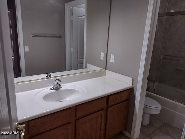 full bathroom featuring combined bath / shower with glass door, vanity, tile patterned flooring, and toilet