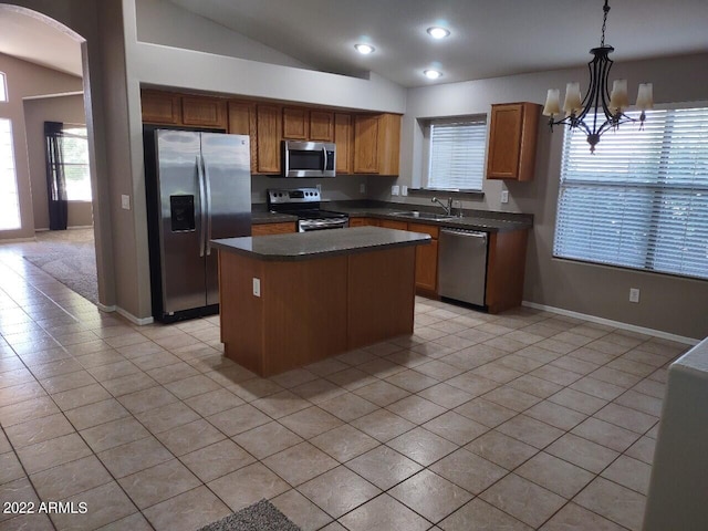 kitchen with a kitchen island, lofted ceiling, decorative light fixtures, light tile patterned floors, and appliances with stainless steel finishes