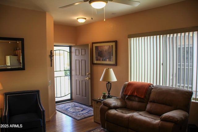 living room with ceiling fan and dark wood-type flooring