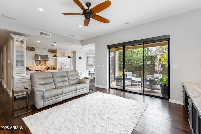 living room featuring dark wood-type flooring and ceiling fan