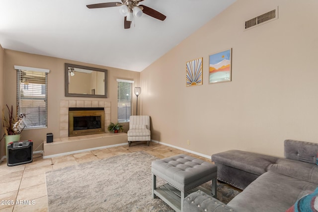 6430 E Riverdale St, Mesa, AZ 85215 - living room with ceiling fan, lofted ceiling, a tiled fireplace, tile patterned flooring, and baseboards