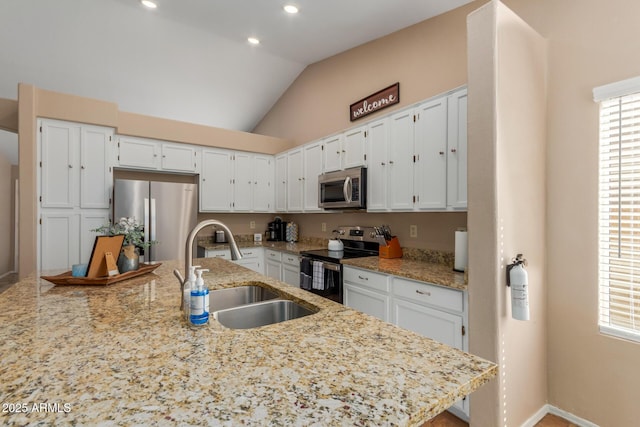 6430 E Riverdale St, Mesa, AZ 85215 - kitchen with appliances with stainless steel finishes, a sink, white cabinetry, light stone counters, and vaulted ceiling