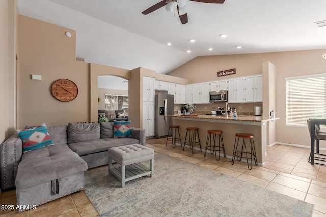 6430 E Riverdale St, Mesa, AZ 85215 - living room featuring light tile patterned floors, ceiling fan, arched walkways, recessed lighting, and high vaulted ceiling