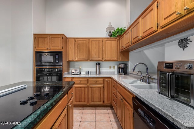 kitchen featuring black appliances, light tile patterned flooring, and sink