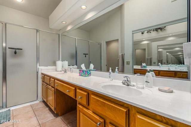 bathroom featuring vanity, vaulted ceiling, a shower with shower door, and tile patterned floors