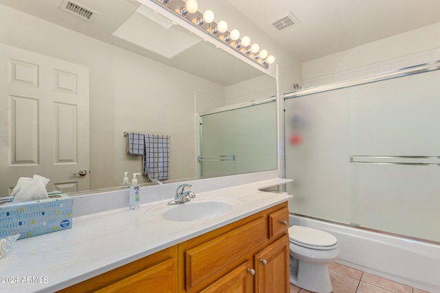 full bathroom featuring tile patterned flooring, toilet, enclosed tub / shower combo, and vanity