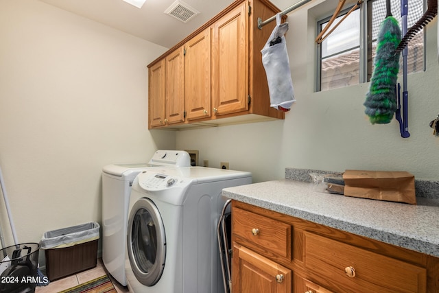 laundry area with separate washer and dryer, cabinets, and light tile patterned floors