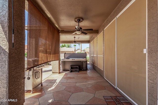 view of patio / terrace with ceiling fan and a hot tub